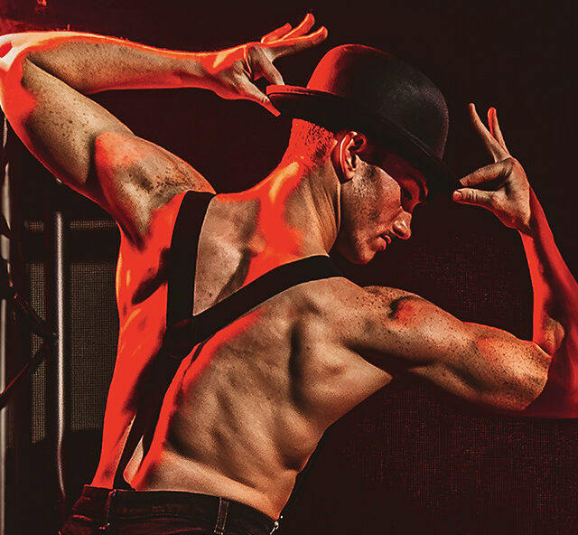 Topless male dancer wearing a black bowler hat and braces