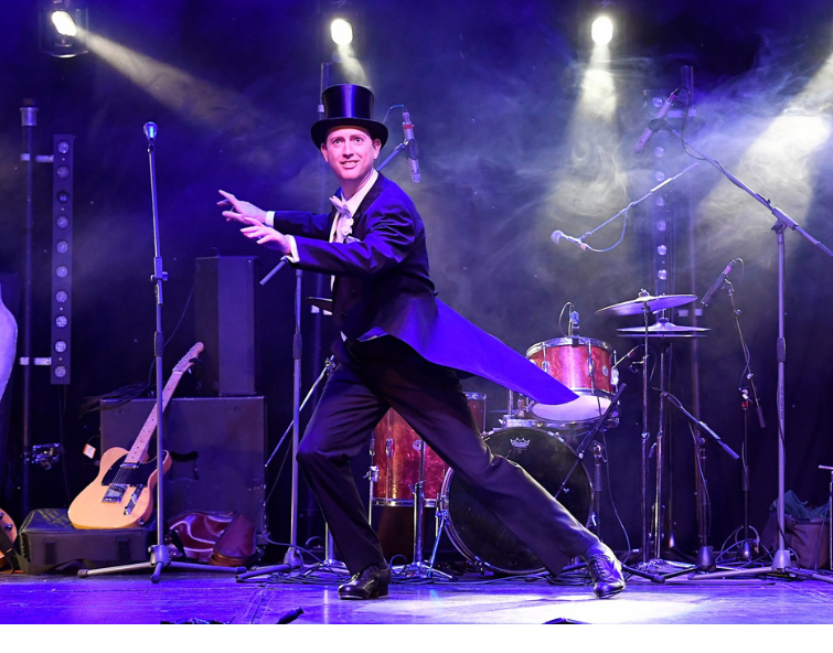 Person in a black top hat and tails tap dancing