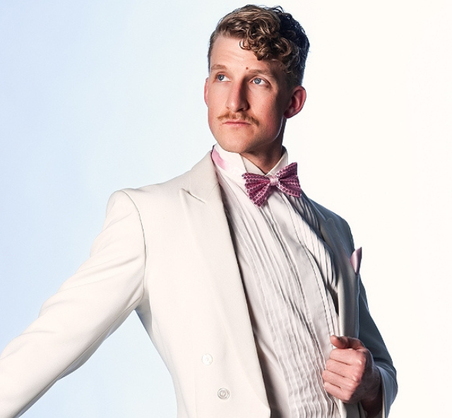 Artist Ziegfeld Boy in a white tuxedo with pink bow tie