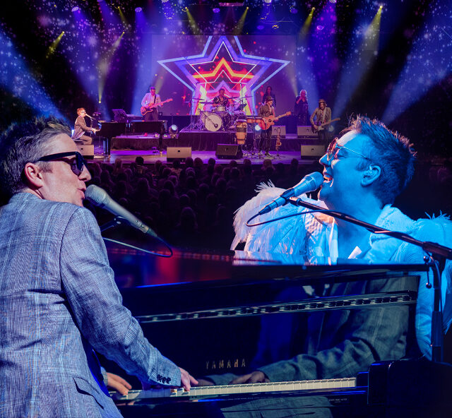 Pianist Jason Dean dressed as both Elton John and Billy Joel sitting at and playing a grand piano