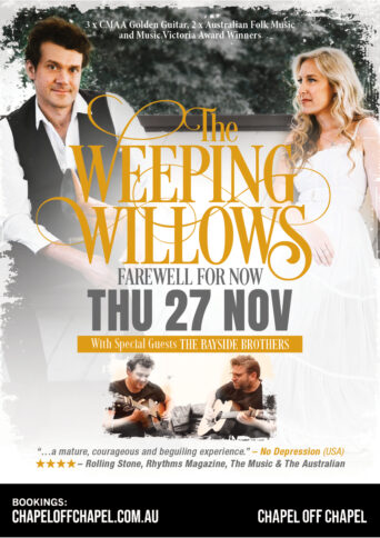 Members of The Weeping Willows Laura Coates in a white dress and Andrew Wigglesworth in a white shirt and black vest sitting on a bench