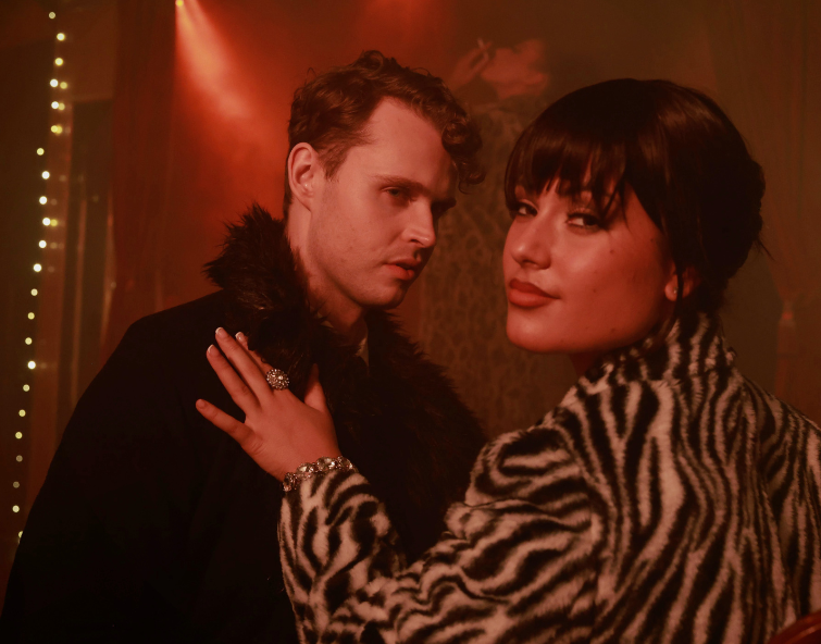 Two people standing in front of each other looking at the camera